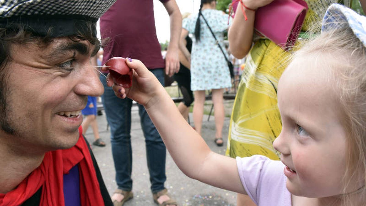 Una niña ucraniana levanta la nariz roja del leonés Nacho Morán durante un espectáculo. JORGE SIERRA