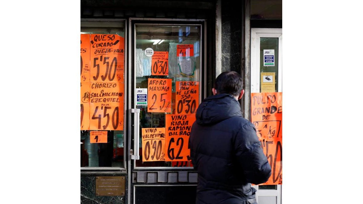 Un hombre pasa ante una tienda de comestibles en León. FERNANDO OTERO