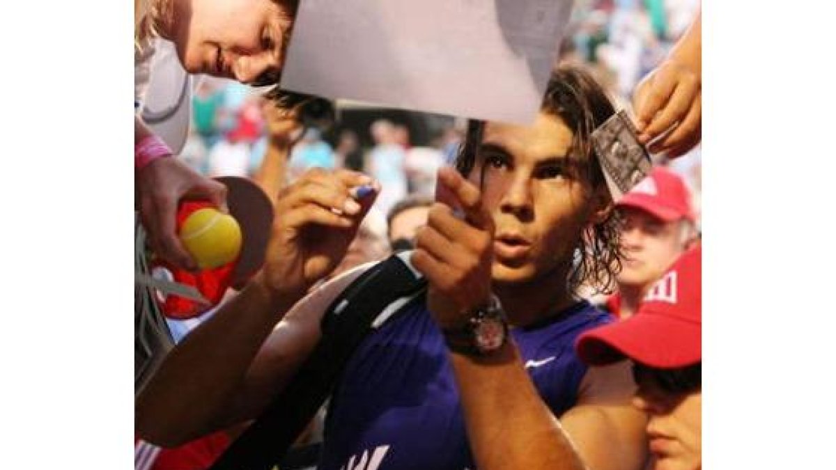 Nadal firma autógrafos tras su derrota ante Djokovic.