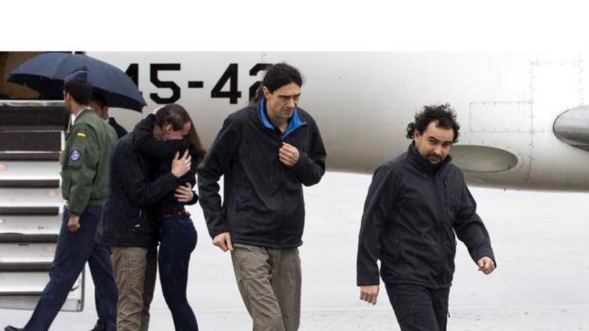 Antonio Pampliega (abrazando a un familiar), José Manuel López y Ángel Sastre a su llegada esta mañana a la Base äerea de Torrejón de Ardoz, en Madrid,
