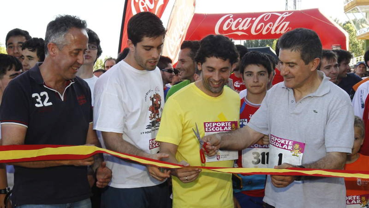Juan Castro, Juanín García y Manolo Cadenas cortan la cinta en la carrera solidaria.