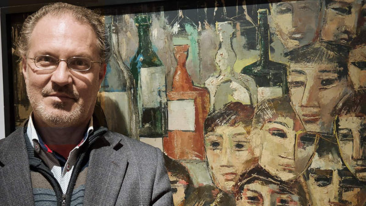 El artista Adolfo Álvarez Barthe posa ante una de las obras de la exposición del ILC. CUEVAS