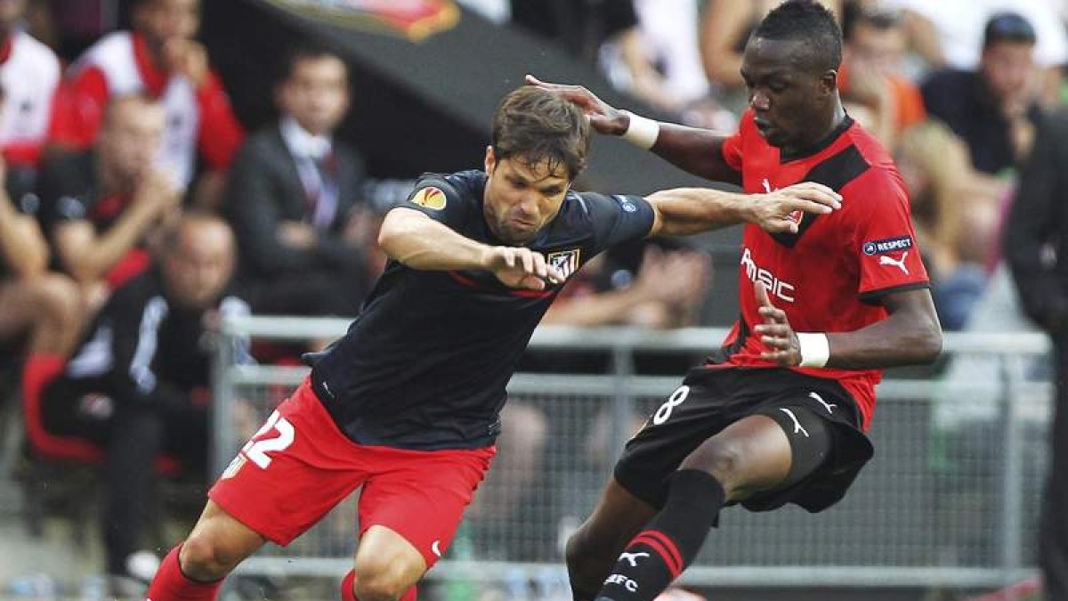 El brasileño del Atlético de Madrid Diego Ribas regatea a Tongo Doumbia, del Stade Rennes.