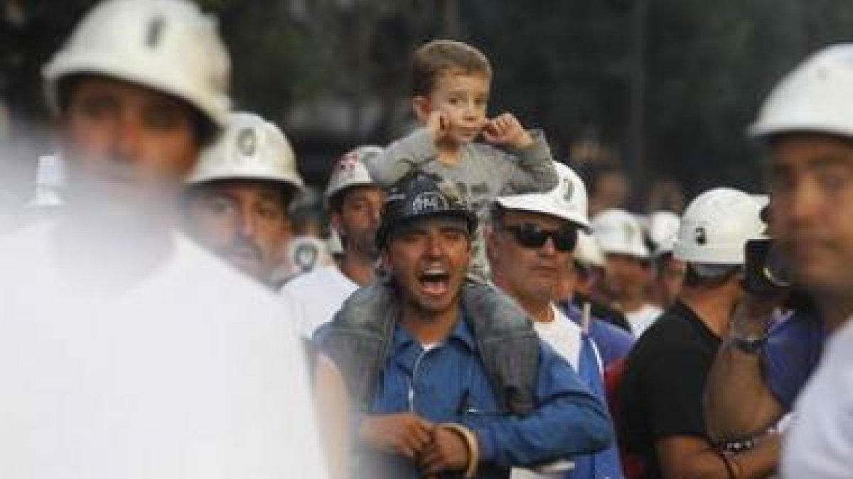 Un niño se tapa los oídos mientras su padre, uno de los mineros de la marcha negra