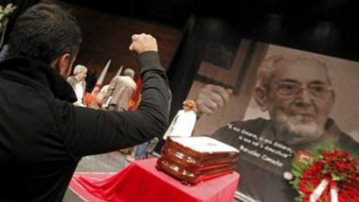 Un joven alza el puño durante su visita a la capilla ardiente del histórico sindicalista, instalada
