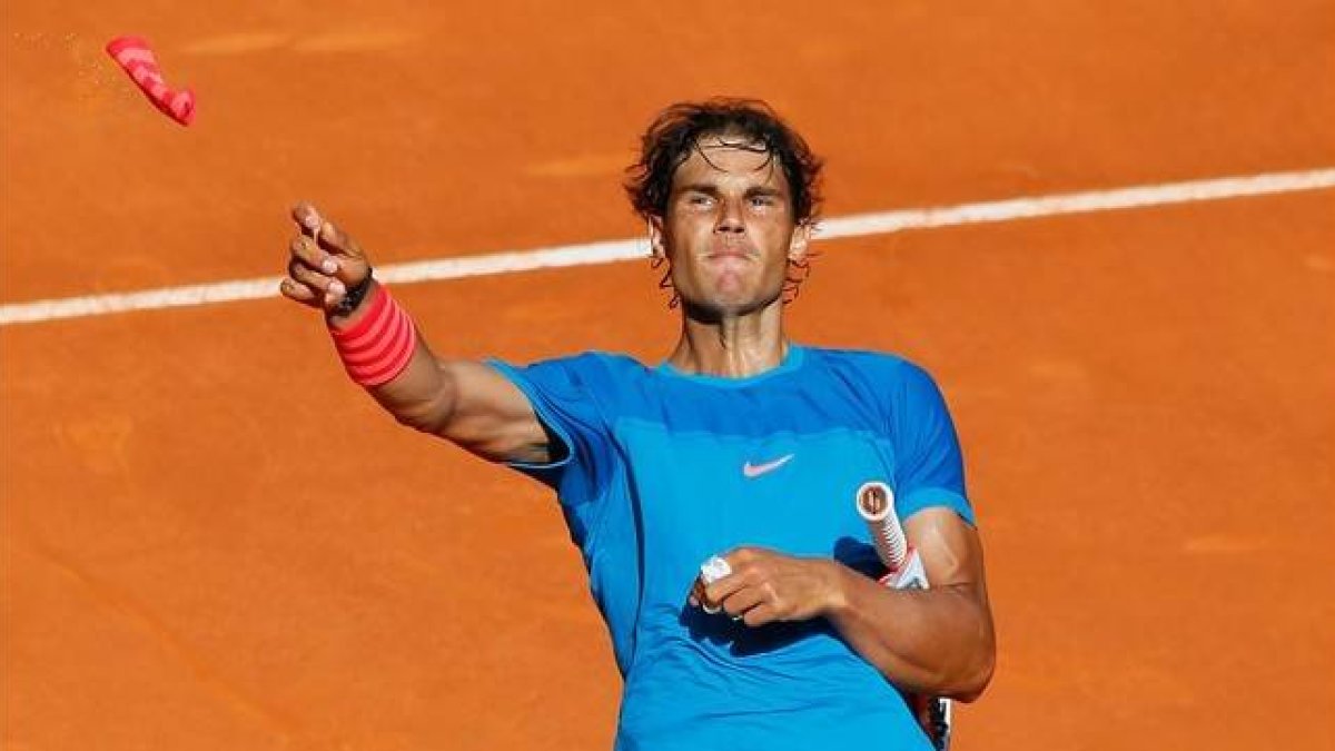 Nadal lanza una de sus muñequeras al público de la Caja Mágica tras derrotar a Dimitrov.