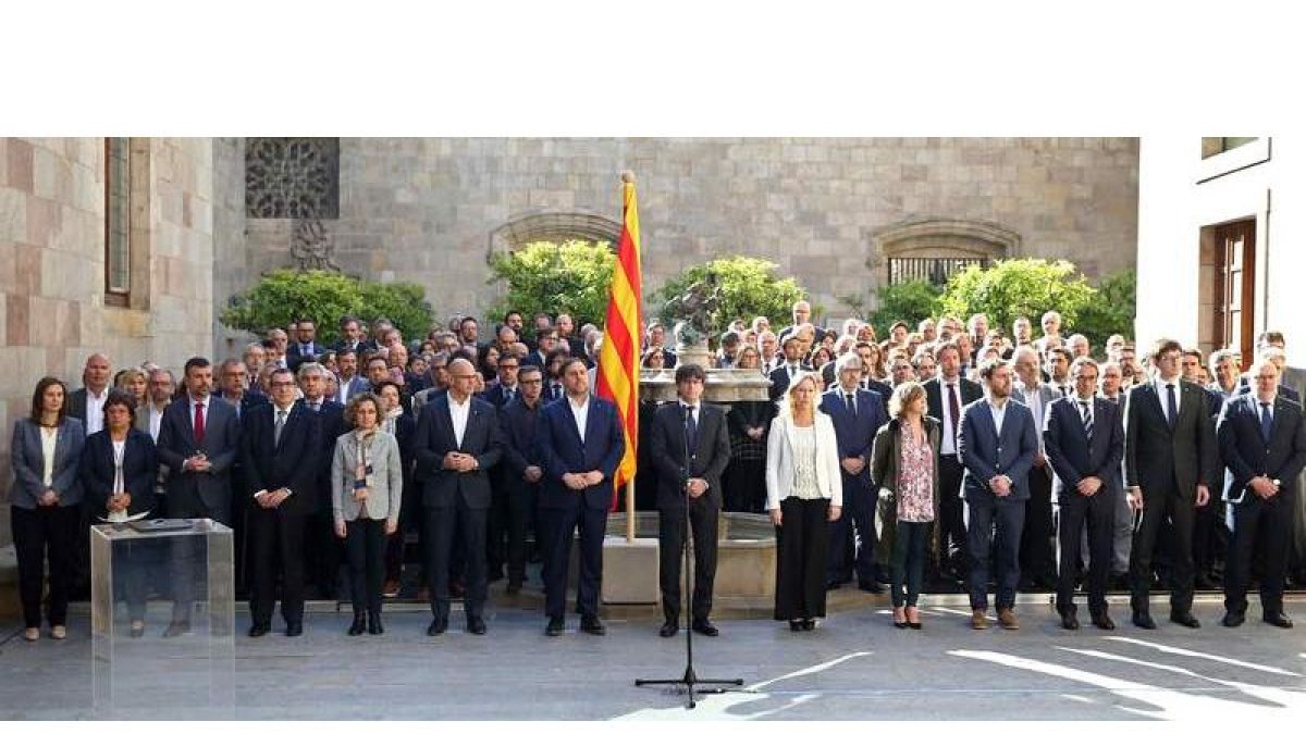 El presidente de la Generalitat, Carles Puigdemont, en el centro, arropado por los miembros de su Gobierno, durante el acto. TONI ALBIR
