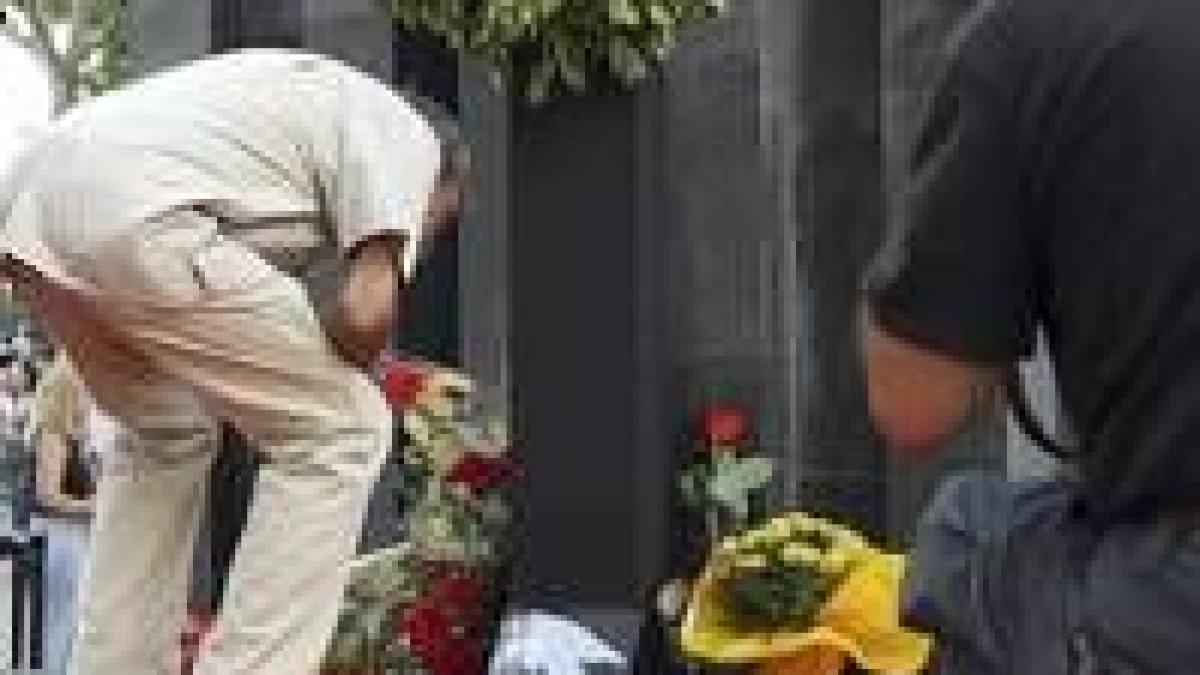 Un hombre lee una placa en recuerdo de los asesinados en Hipercor