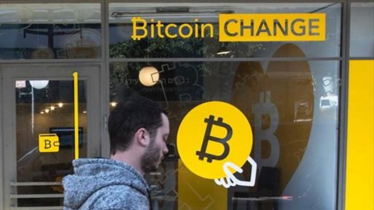 Un ciudadano israelí pasa delante de una oficina de cambio de bitcoines, en Tel-Aviv.