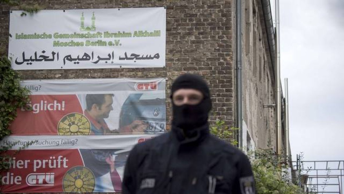 Un oficial de la policía alemana espera fuera de una asociación musulmana supuestamente vinculada a una trama de apoyo al yihadismo en Siria.