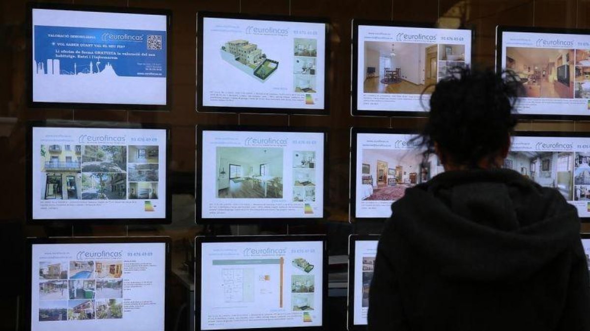 Ofertas de ventas de pisos en el escaparate de una inmobiliaria.