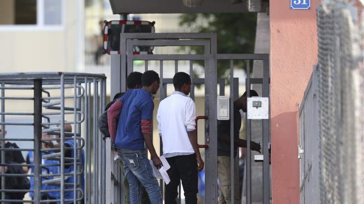 Un grupo de refugiados llega al centro donde ayer explotó una maleta con aerosoles. DANIEL KARMANN