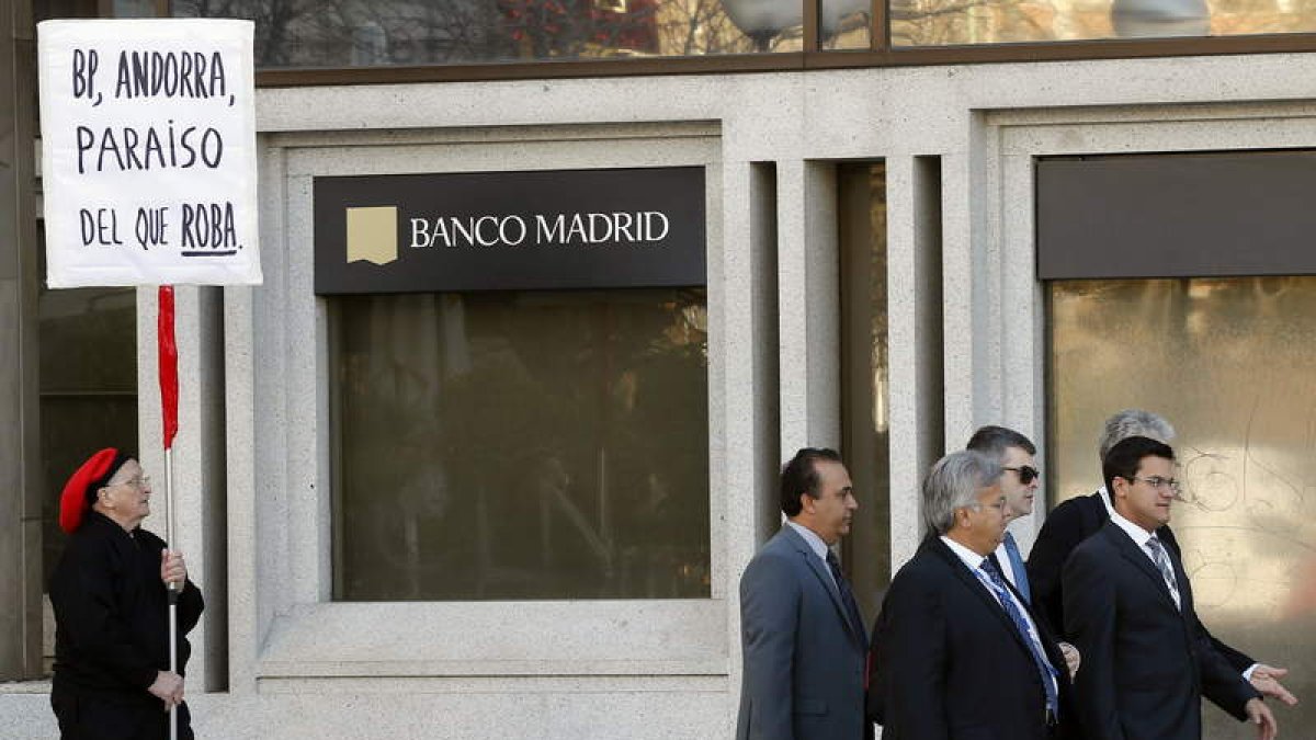 Un hombre protesta ante la sede de Banco Madrid intervenido por el Banco de España.