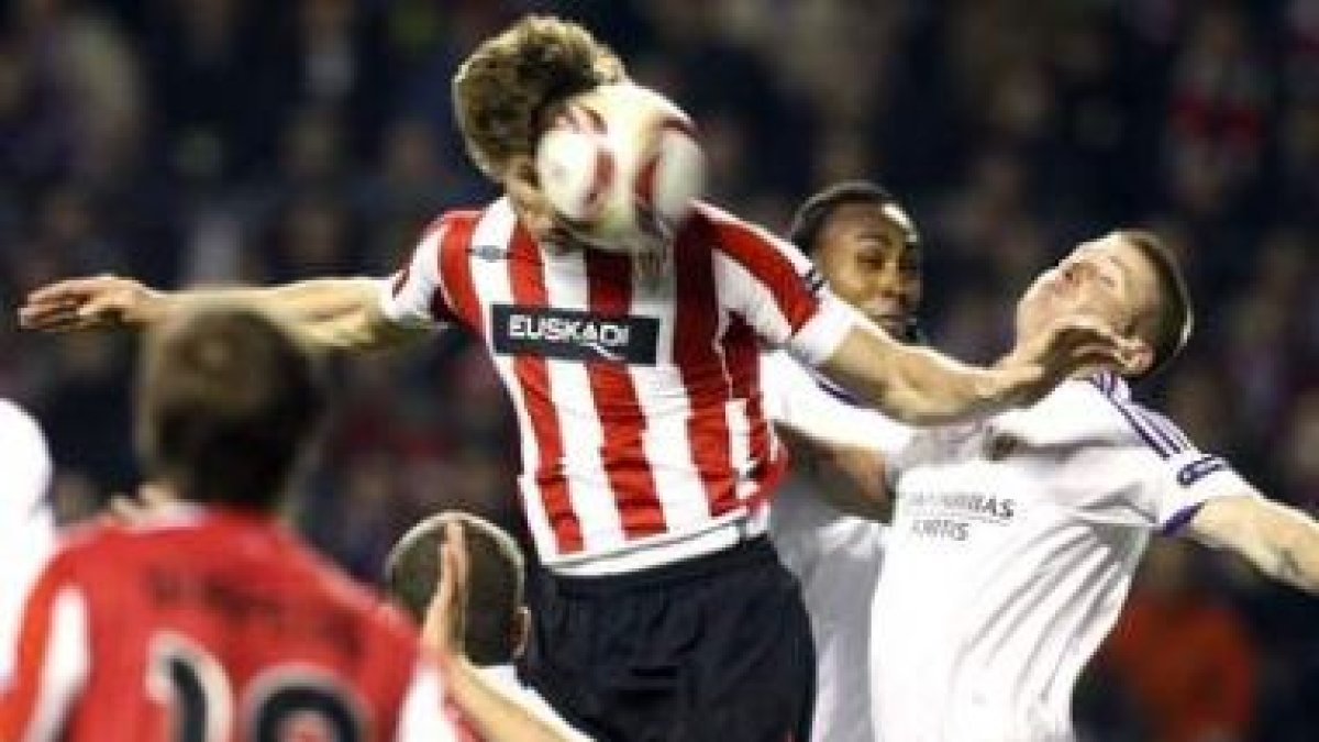 Llorente cabecea el balón ante la oposición de un rival.