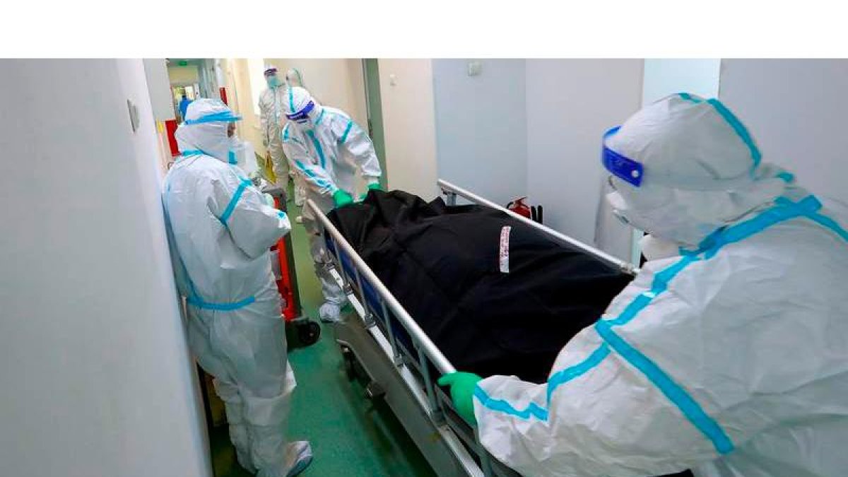 Trabajadores sanitarios sacan a un fallecido en un hospital de Rumanía. ROBERT GHEMENT