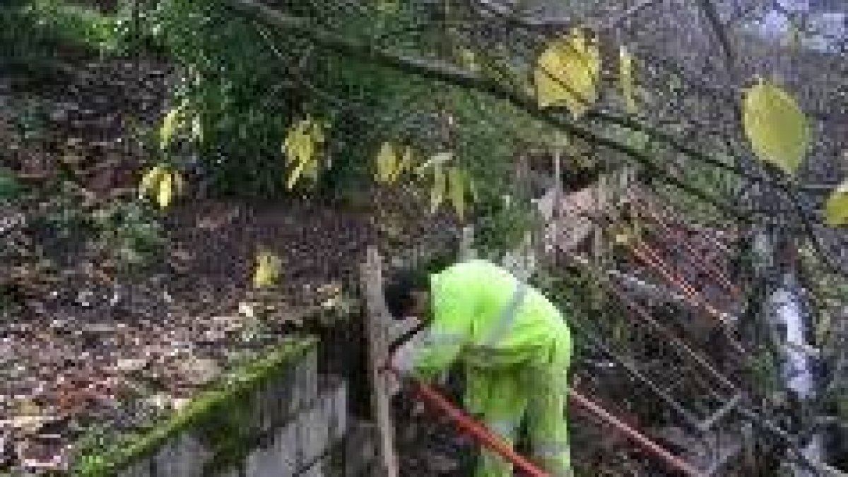 Operarios municipales, ayer en el momento de proceder a la restauración del muro deteriorado
