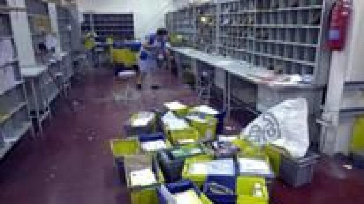 Una empleada limpia el lugar donde ayer hizo explosión el paquete bomba