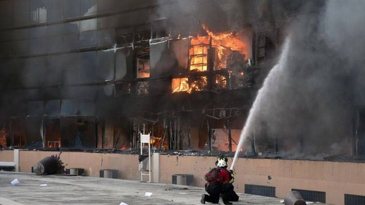 Un bombero intenta apagar el fuego de un edificio del complejo de la alcaldía de Chilpancingo.