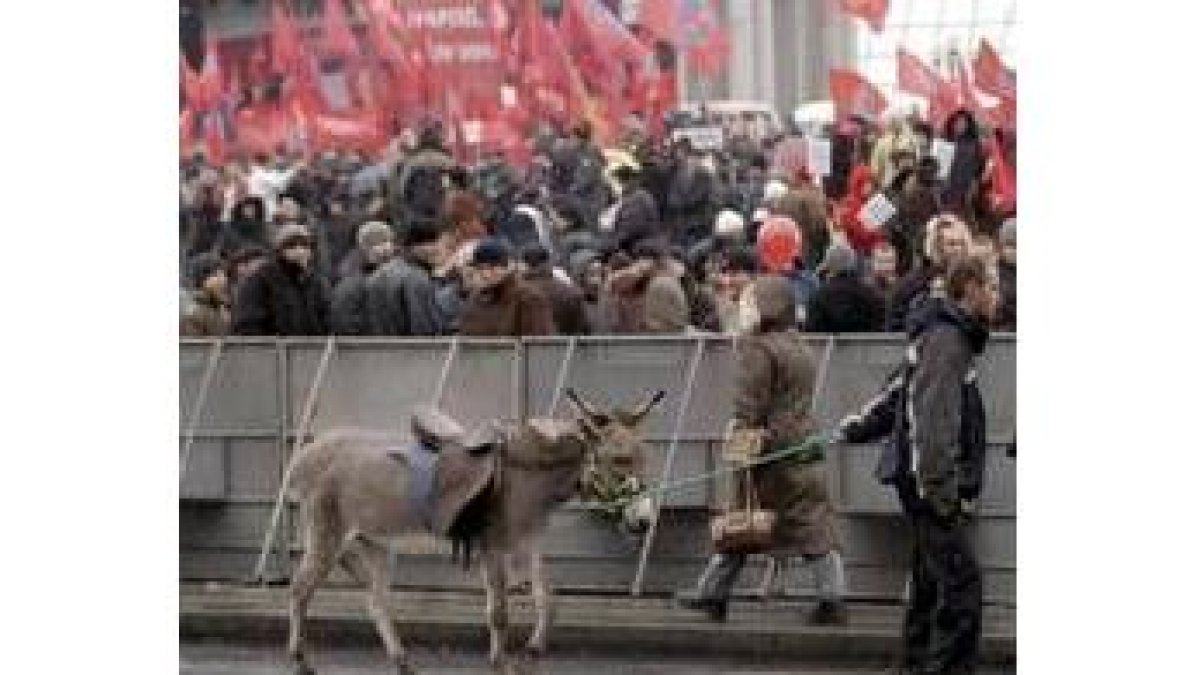Un joven ucraniano pasa con su burro por delante de una protesta contra Yushchenko