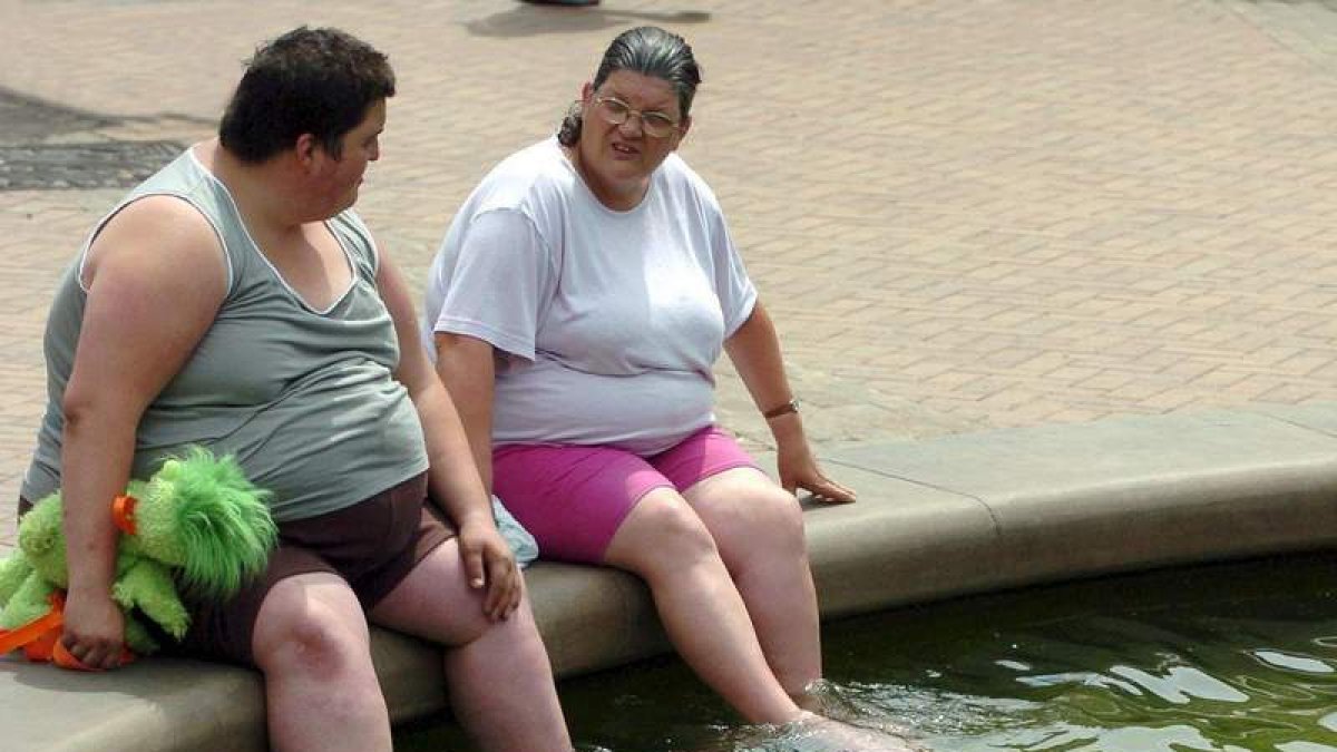Dos personas se refrescan en una fuente en Inglaterra. KIYOSHI OTA