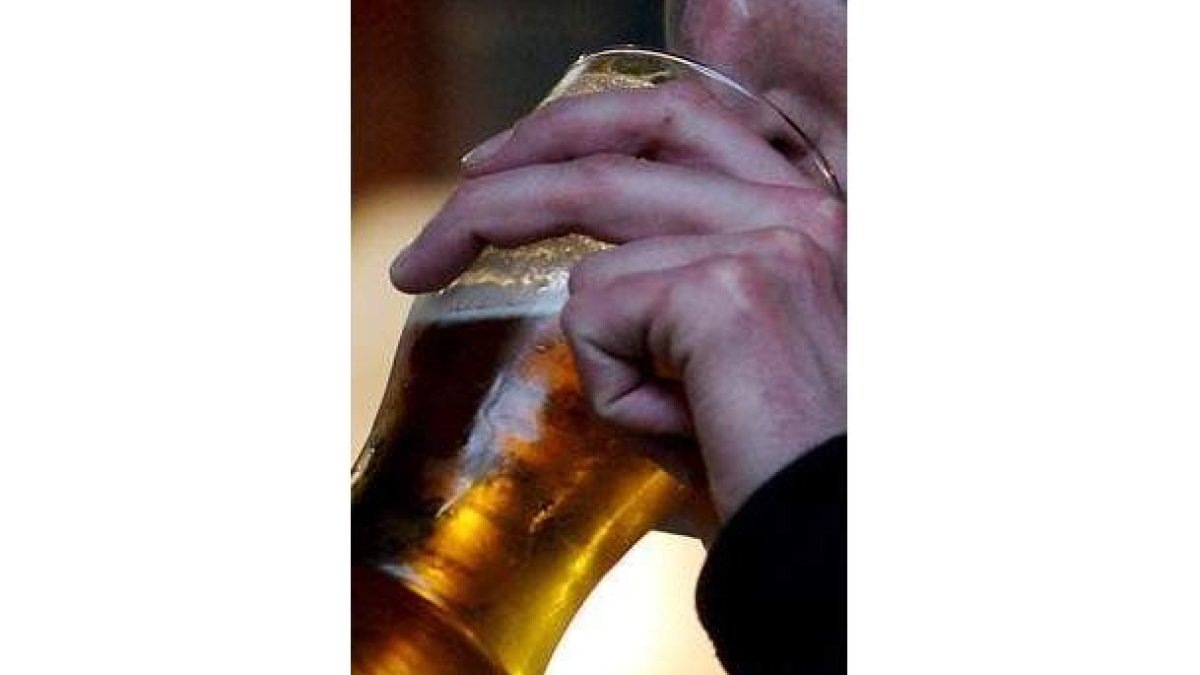 Un hombre bebe una pinta de cerveza en un bar.