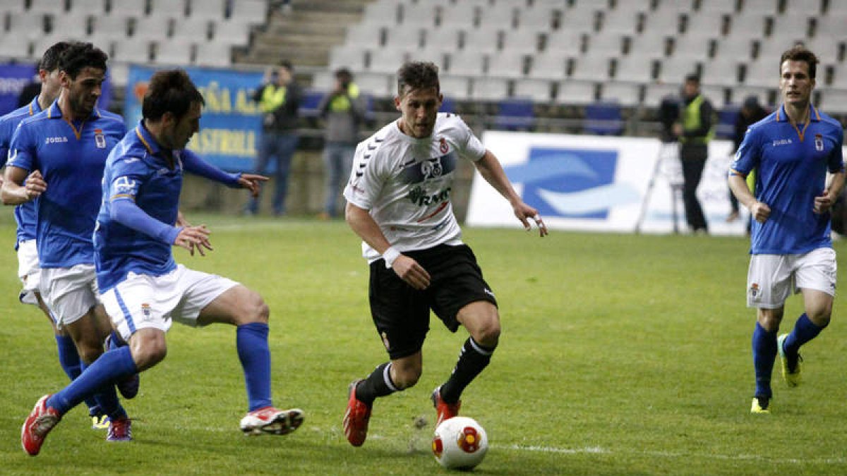 El culturalista Góngora conduce el balón rodeado de adversarios del Real Oviedo. Precisamente de las botas del lateral izquierdo surgió el servicio del gol anulado a Diego Torres.