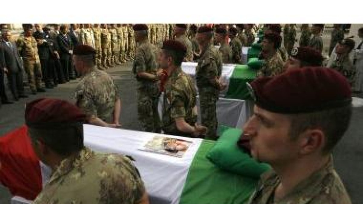 Varios soldados custodian los féretros de los soldados caídos en Kabul, antes de iniciar el cortejo.