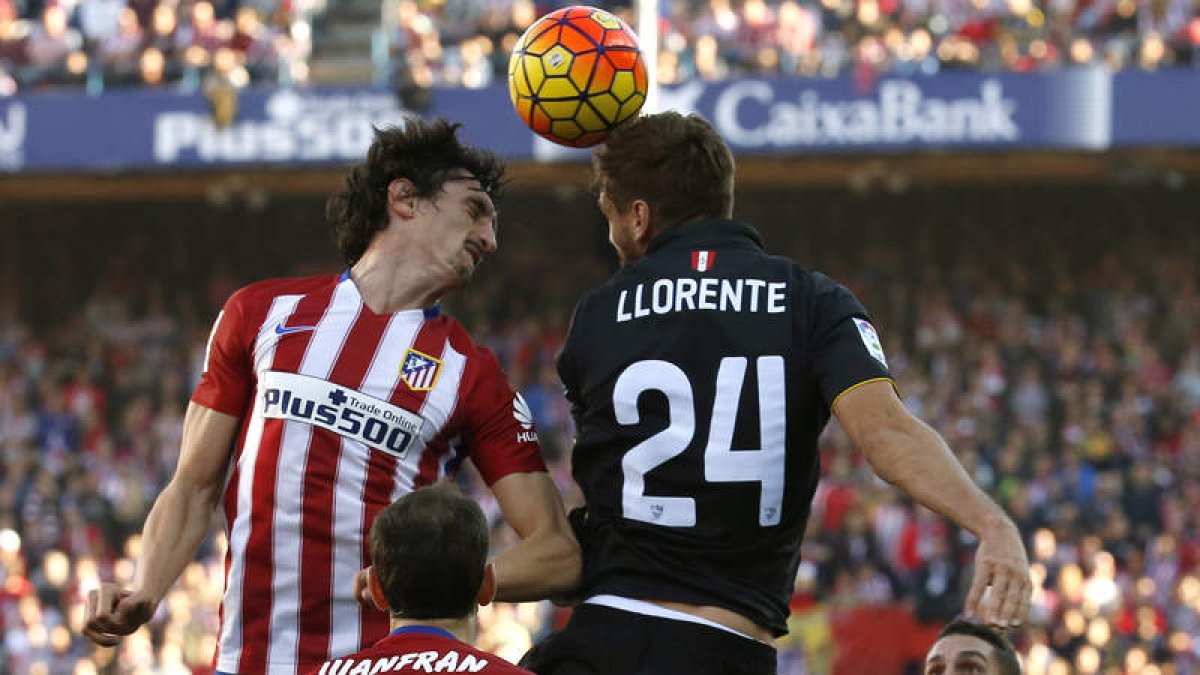 Fernando Llorente del Sevilla y Stefan Savic del Atlético luchan por el balón.