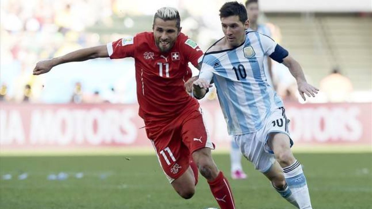 Messi controla el balón ante el acoso de Behrami.