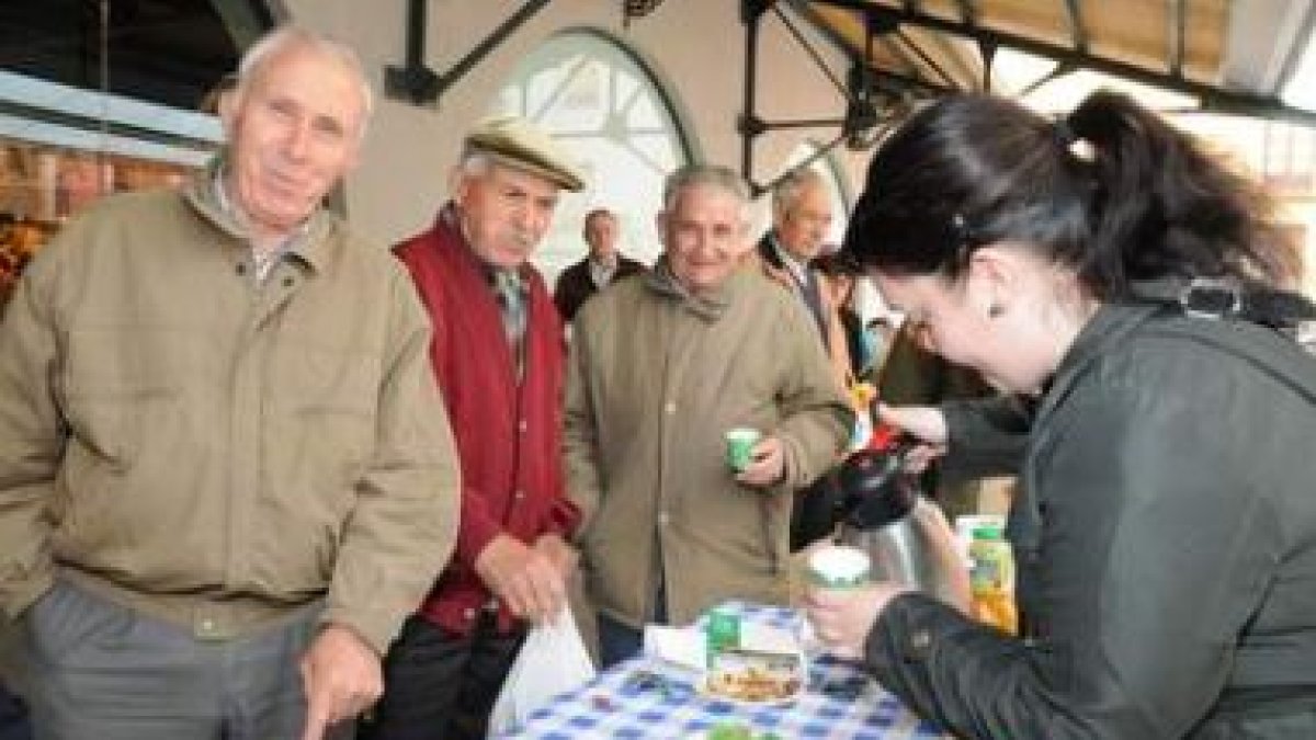 Varios leoneses degustan el Café Justo en el Ecomercado de León.