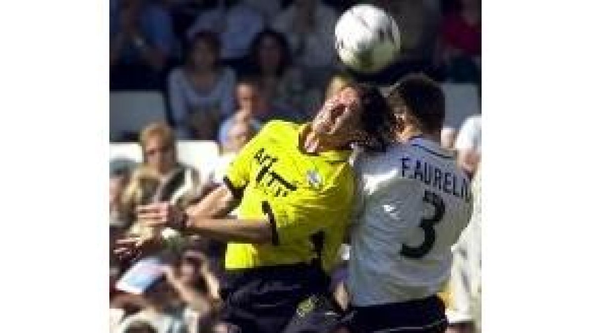 Helguera se lleva la pelota ante la oposición de Fabio Aurelio