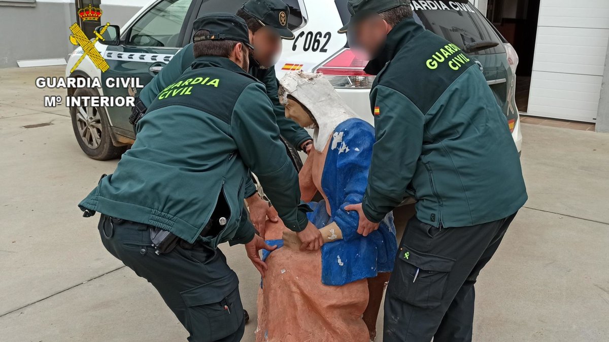 Los guardias civiles con la talla de la Virgen, robada del belén instalado en la Plaza Mayor de Laguna de Negrillo. GUARDIA CIVIL/MINISTERIO DEL INTERIOR