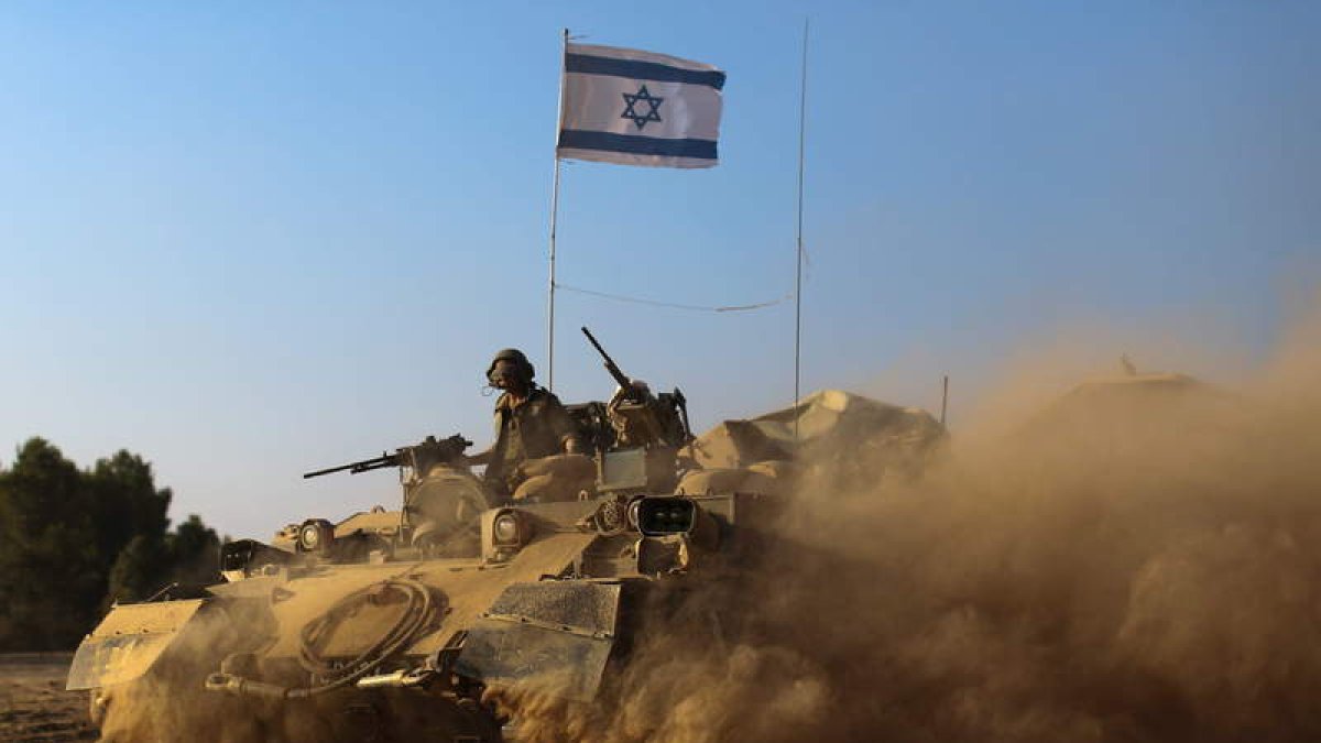 Un tanque del Ejército israelí en su camino hacia la franja de Gaza rodeado de polvo.