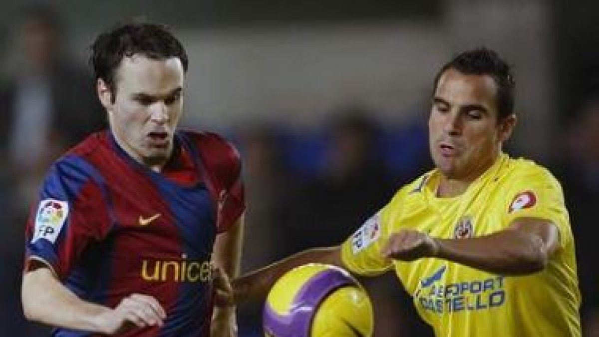 Andrés Iniesta pelea un balón con el defensa Ángel Domingo López.