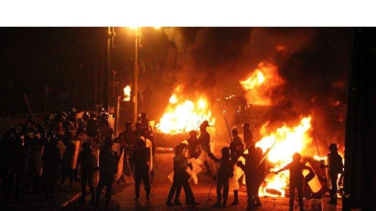 Fuerzas de seguridad de egipto desplegadas mientras los vehículos arden en llamas durante una protesta de cristianos coptos en El Cairo, hoy.
