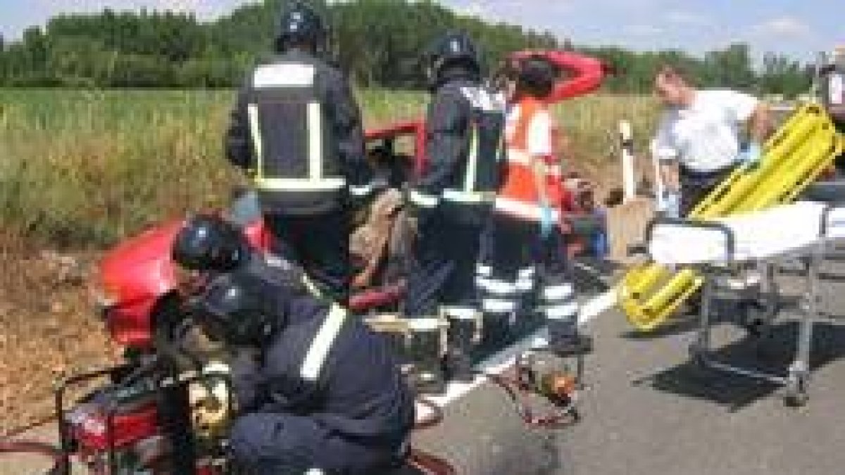 Imagen de los bomberos de León cortando el metal del vehículo para liberar a su conductor