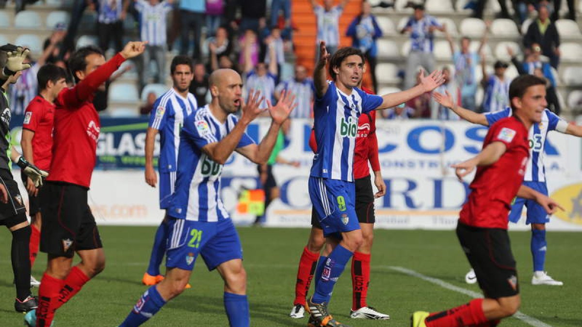 Berrocal y Pablo Infante celebran el gol que le dio a la Deportiva otros tres puntos y que le colocaba líder provisional, mientras los jugadores del Mirandés protestan al colegiado que el balón había traspasado la línea.