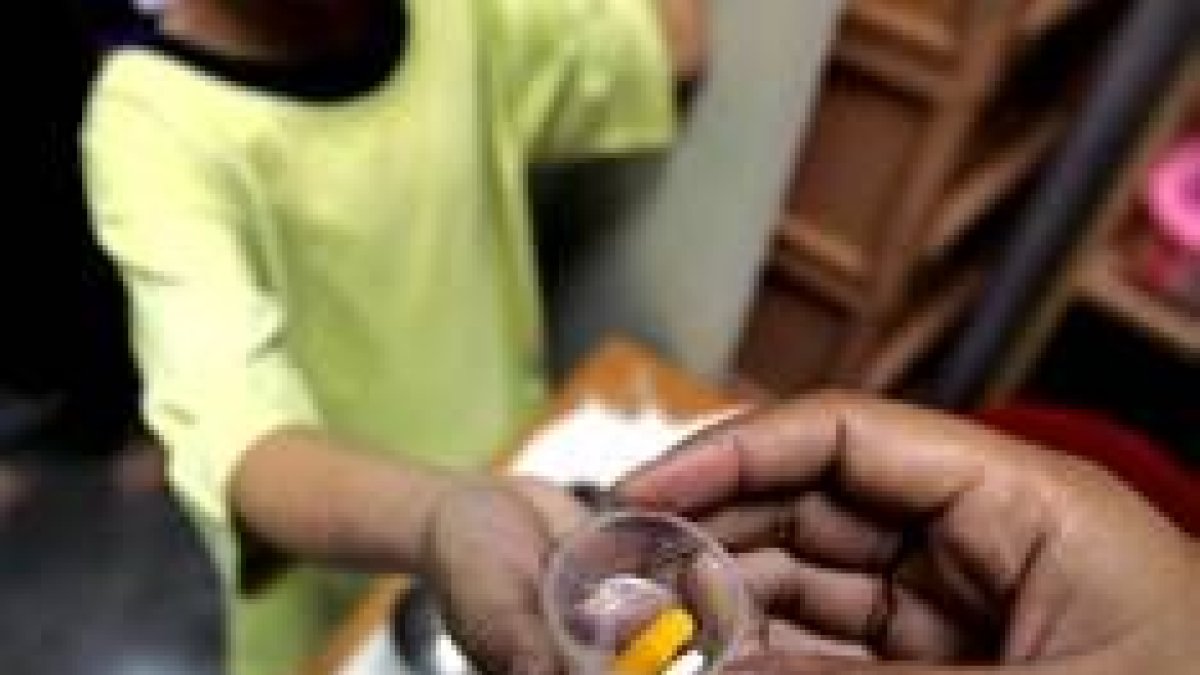 Un huérfano seropositivo recibe medicación en un centro médico de Bangkok