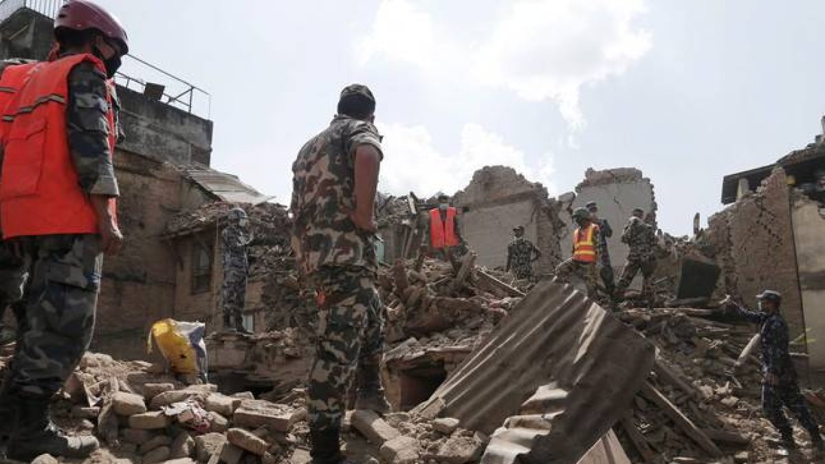 Soldados y equipos de rescate nepalís buscan supervivientes entre los escombros de los edificios caídos tras el terremoto.