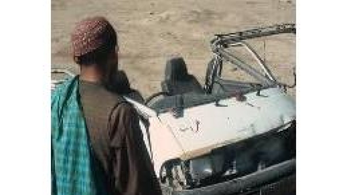 Un afgano mira el autobús destrozado por la explosión