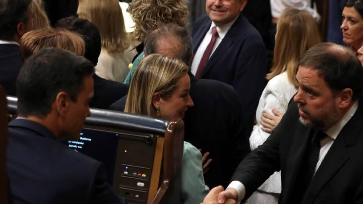 Pedro Sánchez (i), saluda al diputado electo en prisión preventiva de ERC Oriol Junqueras, durante la sesión constitutiva de las nuevas Cortes Generales