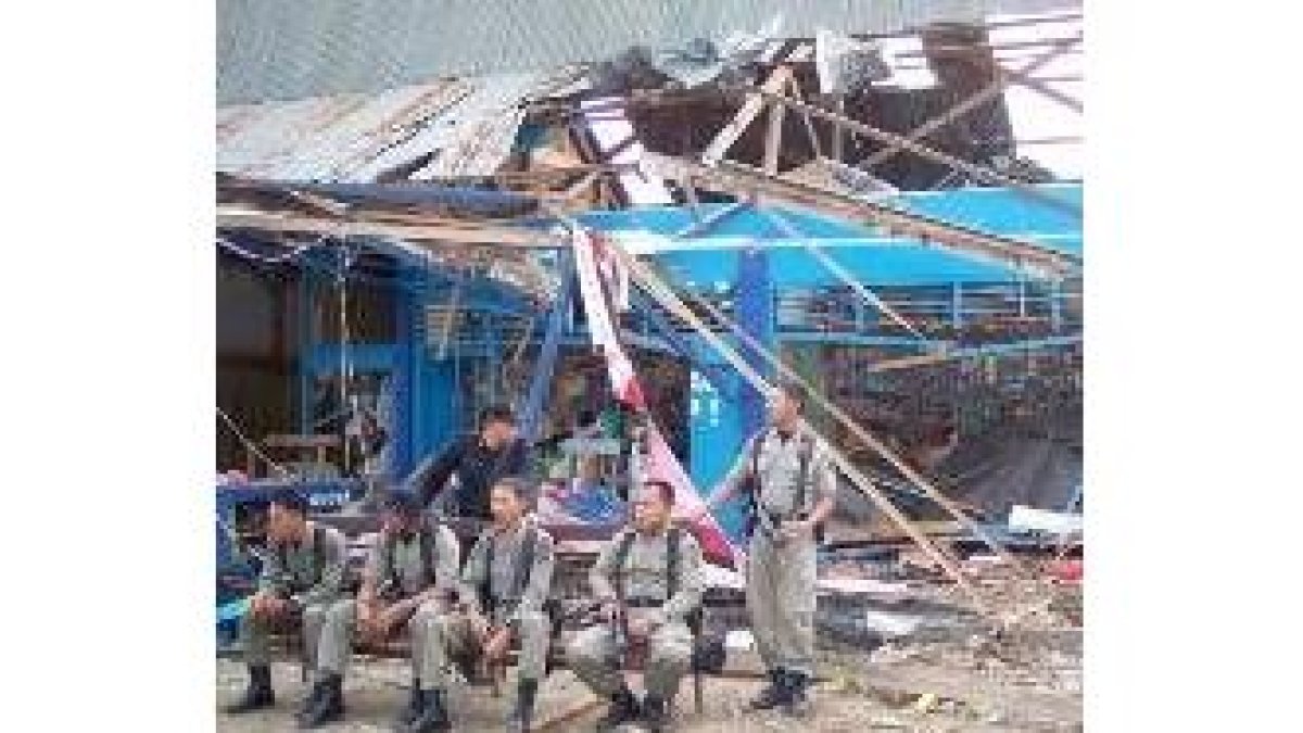Policías indonesios esperan en un banco antes de su inspección