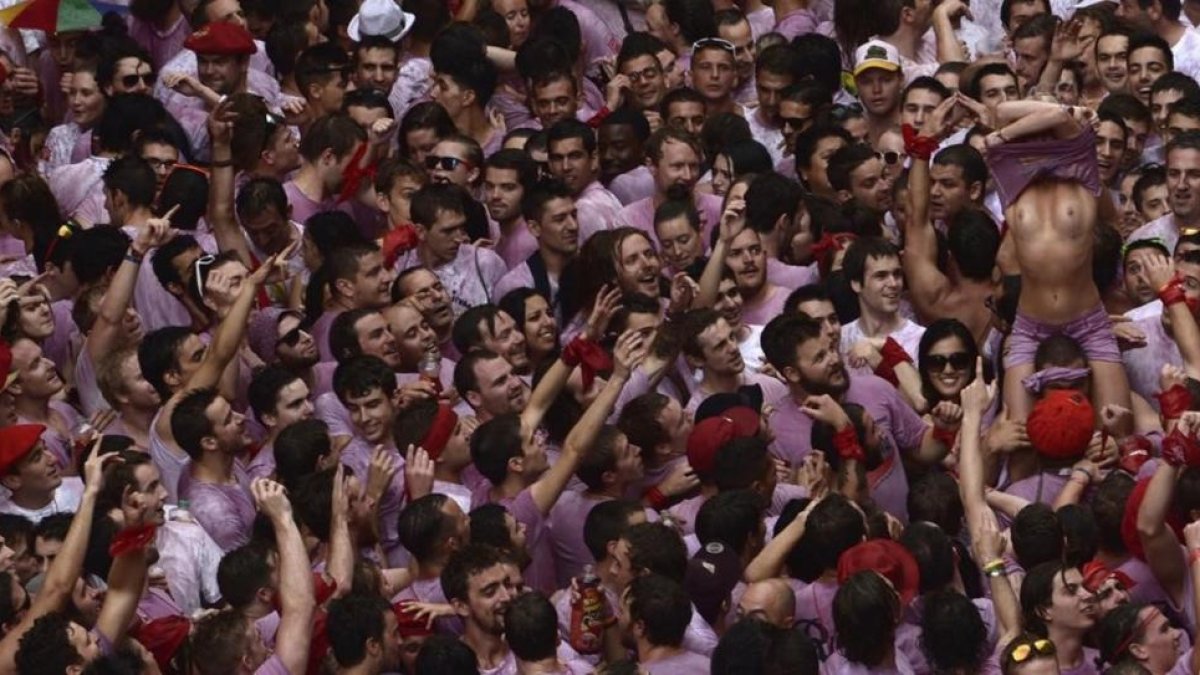 Una joven desnuda su torso en medio del gentío tras el chupinazo de los Sanfermines del 2014.
