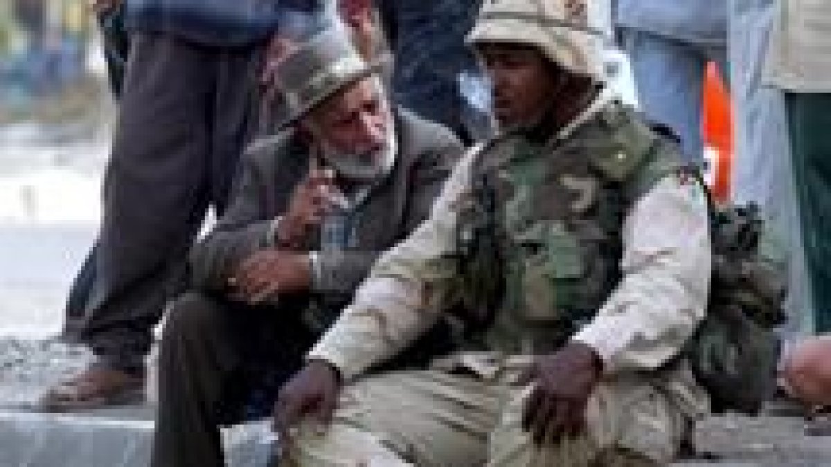 Un iraquí charla con un marine que descansa en uno de los puestos de control establecidos en Bagdad