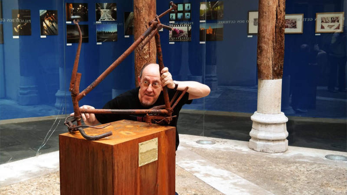 El artista Agustín Berrueta posa con una de las obras de la exposición.