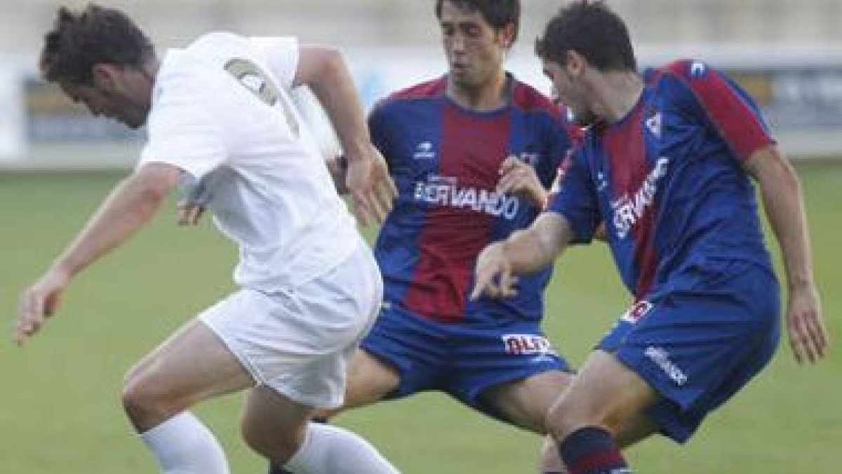 El delantero Viola, a la izquierda, trata de llevarse el balón entre dos contrarios.