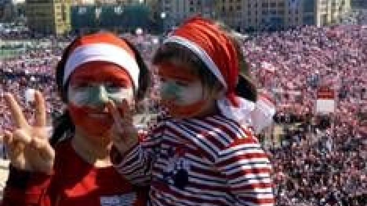 Una mujer y su hija pequeña hacen la señal de la victoria en la macromanifestación de Beirut