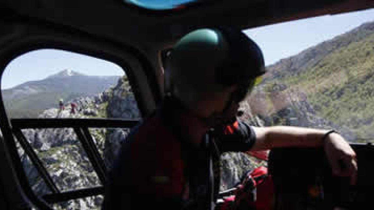 Un agente de Protección Civil vigila desde el helicóptero la labor de sus compañeros