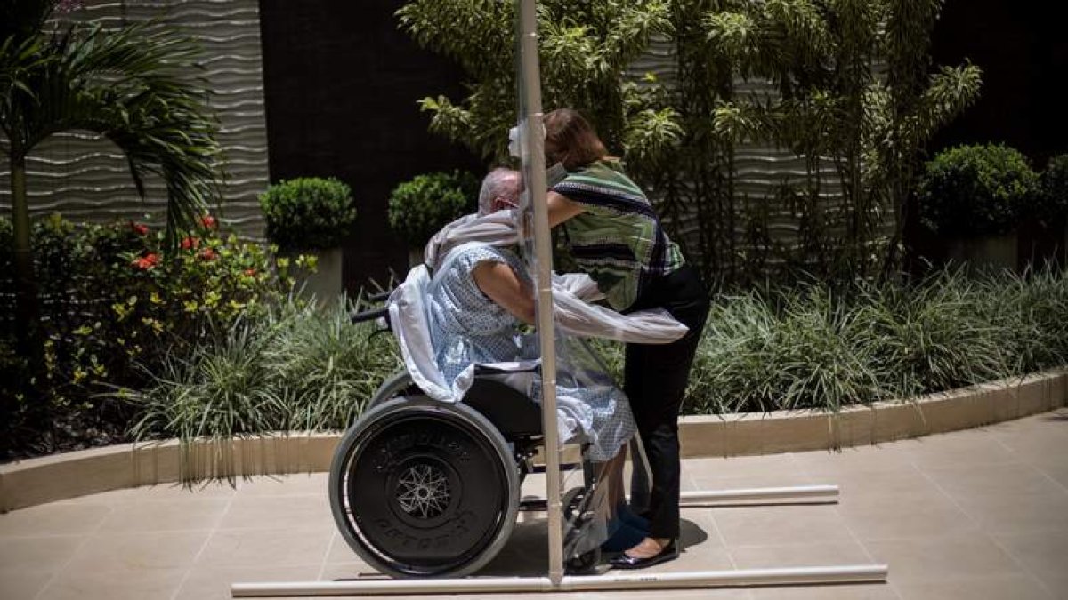 Una pareja celebrará 50 años de matrimonio en Brasil con un abrazo a través de una lámina de plástico. ANTONIO LACERDA