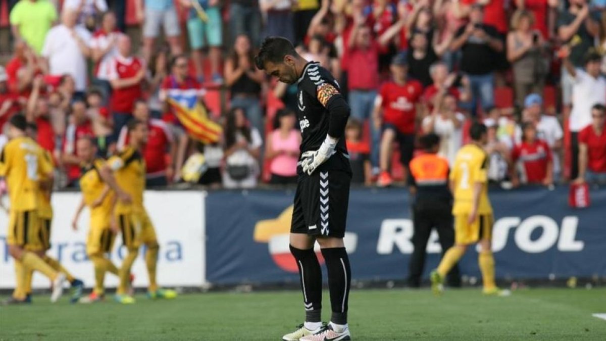 El portero del Nàstic, Manolo Reina, muestra su aflicción mientras los jugadores de Osasuna celebran uno de sus goles.